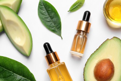 Flat lay composition with essential oil and avocado on white background