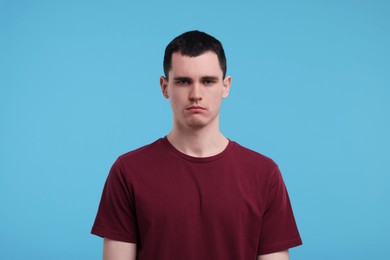 Photo of Portrait of sad man on light blue background