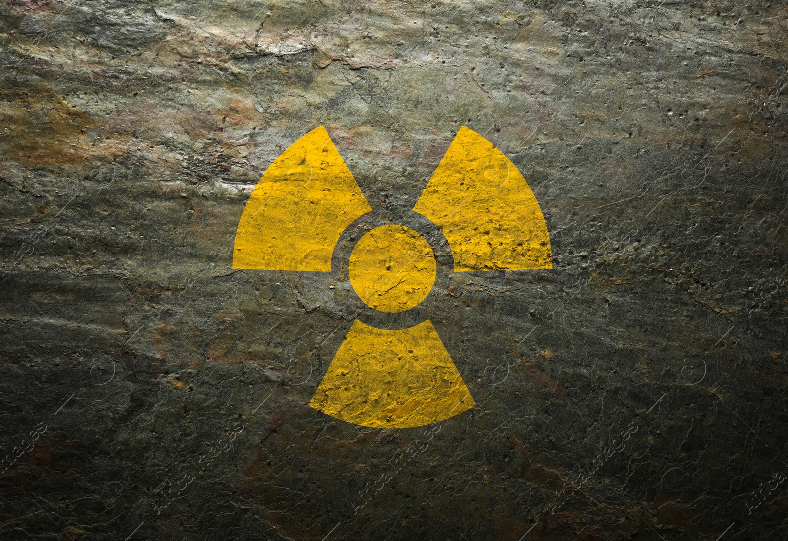 Image of Radioactive sign on grey stone wall. Hazard symbol