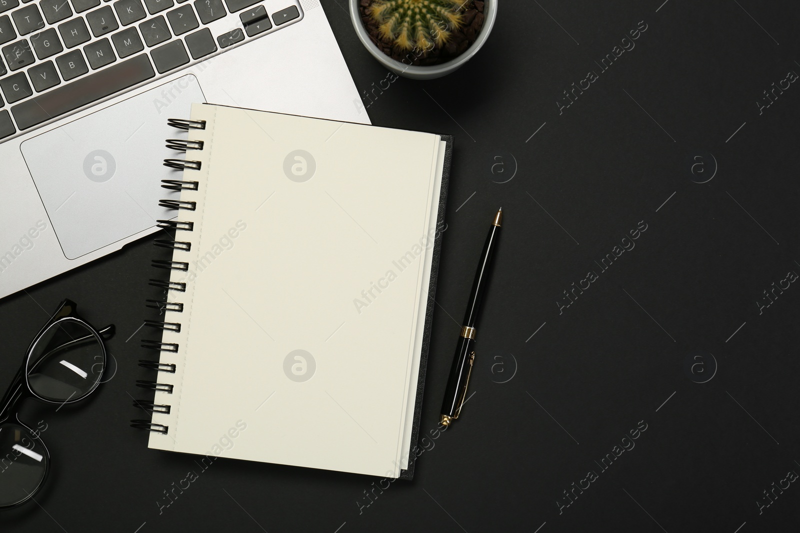 Flat lay composition with notebook and laptop on black table. Space for text Photo of Flat lay composition with notebook and laptop on black table. Space for text