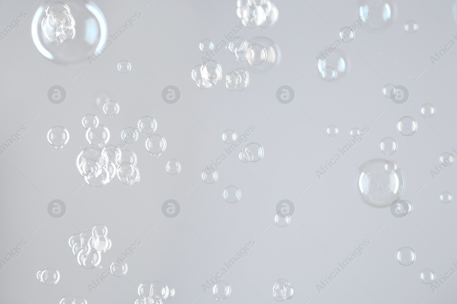 Photo of Beautiful transparent soap bubbles on light grey background