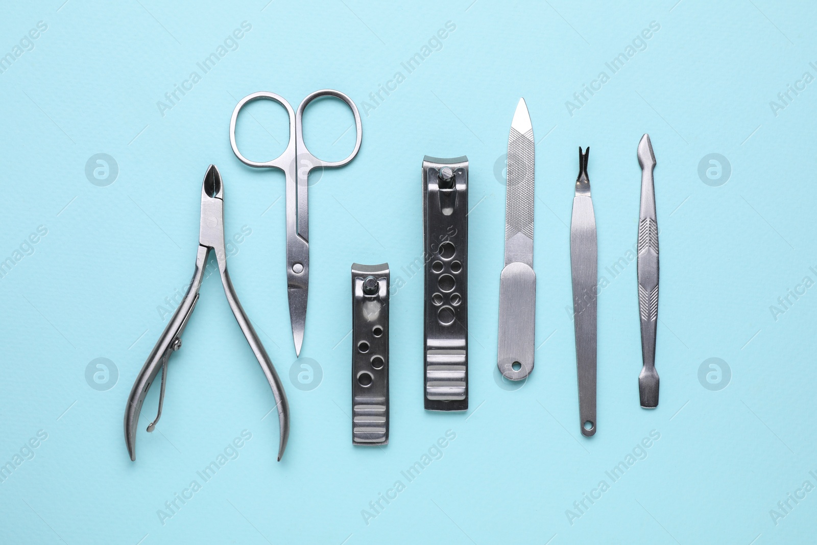 Photo of Set of pedicure tools on light blue background, flat lay