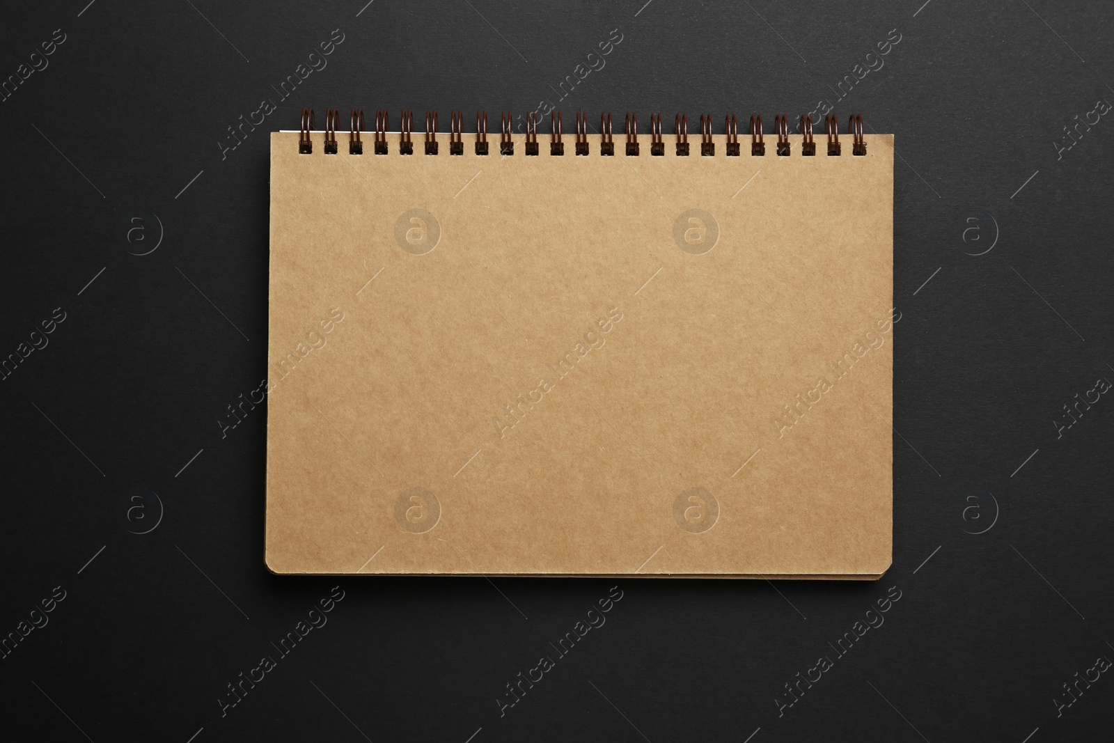 Photo of One notebook on black background, top view