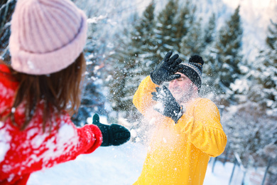 Happy couple playing snowballs outdoors. Winter vacation