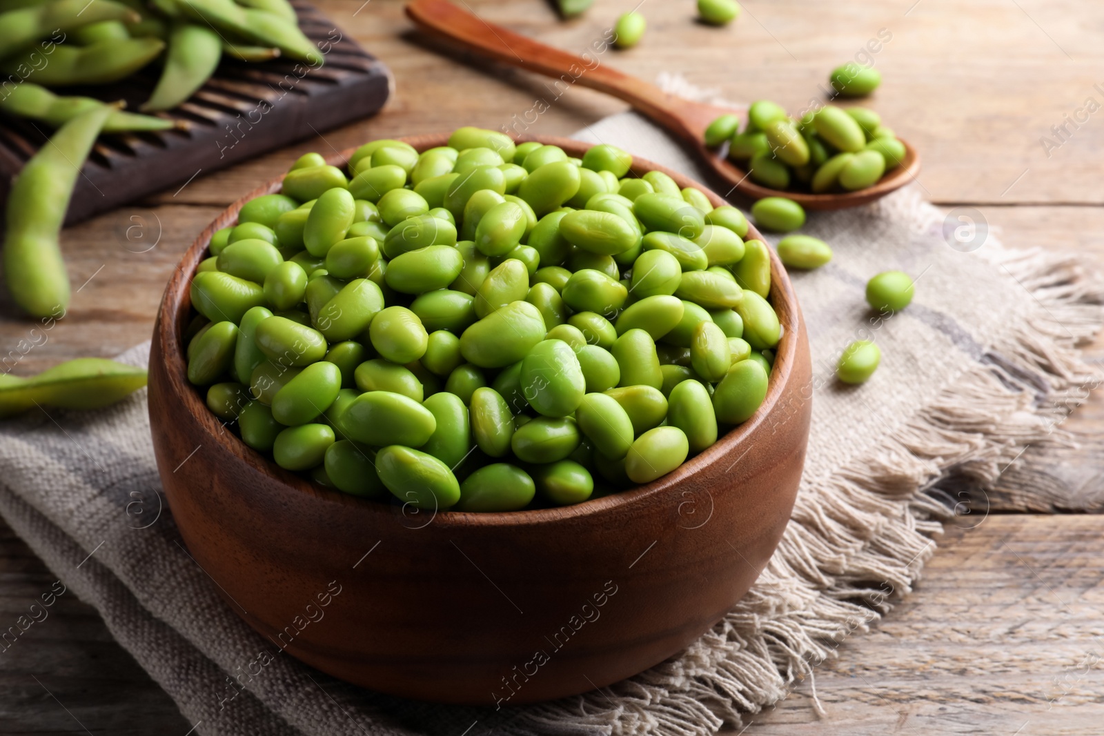 Photo of Bowl of delicious edamame beans on wooden table