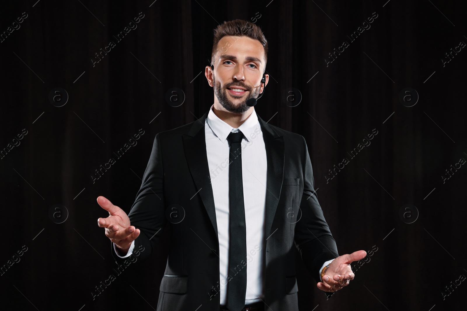 Photo of Motivational speaker with headset performing on stage