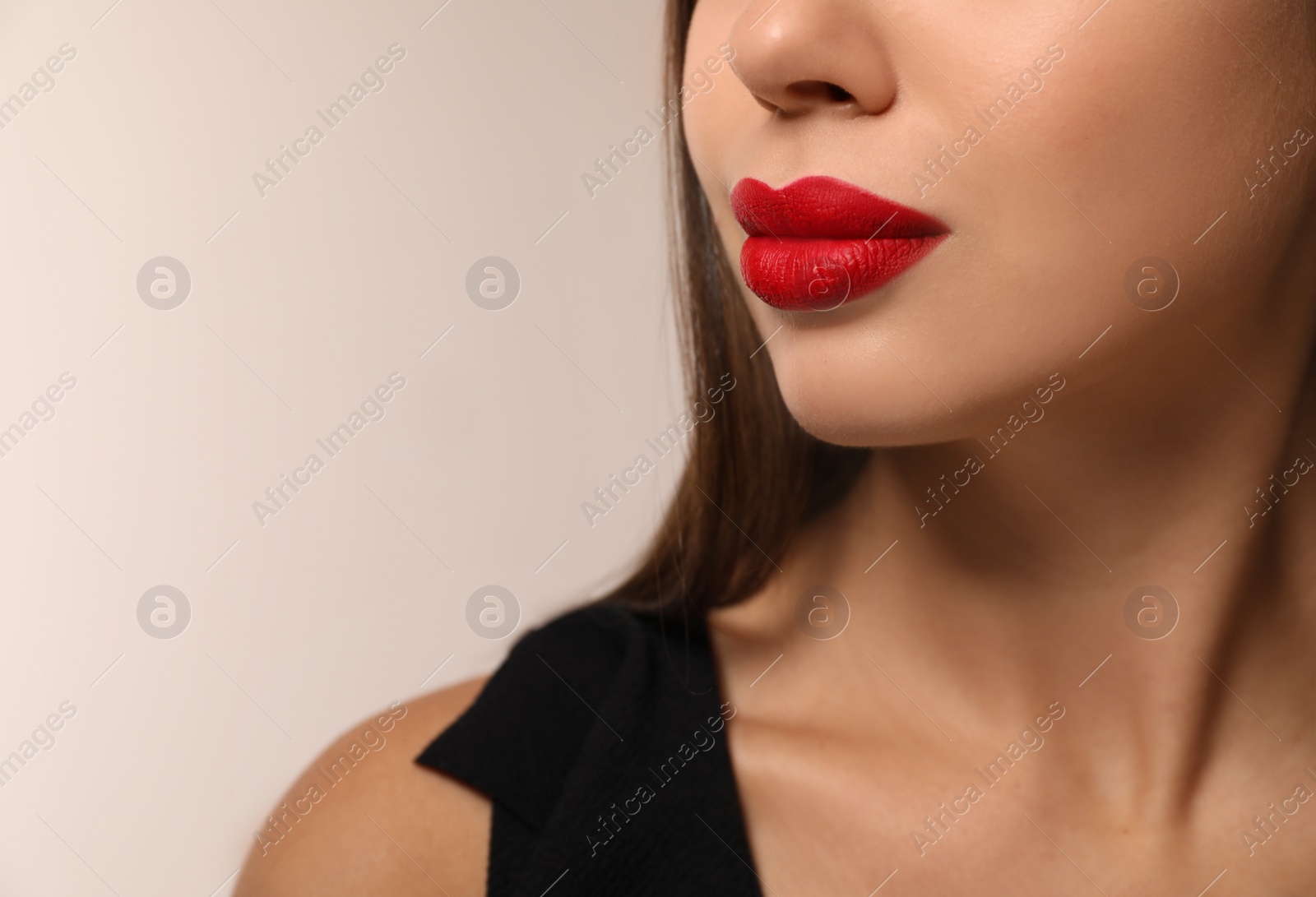 Photo of Beautiful woman with red lipstick on light background, closeup. Space for text