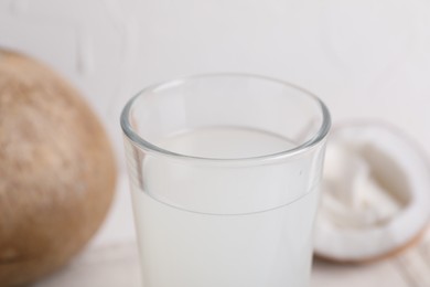 Glass of coconut water on white table, closeup