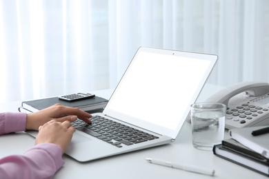 Young woman using modern computer at table indoors, closeup. Space for design