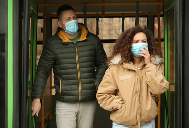 People with disposable masks going out of bus outdoors. Virus protection