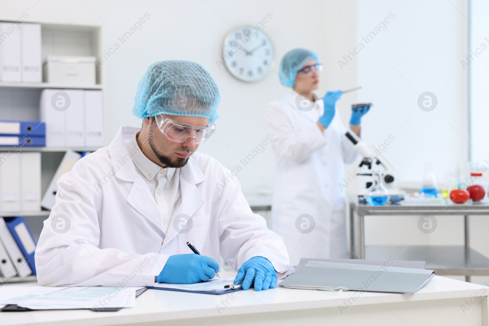 Photo of Quality control. Food inspectors checking safety of products in laboratory