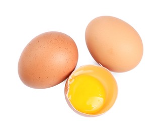 Photo of Whole and cracked chicken eggs isolated on white, top view