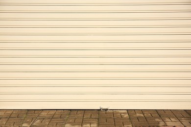 Photo of Closed white roller shutter garage door outdoors