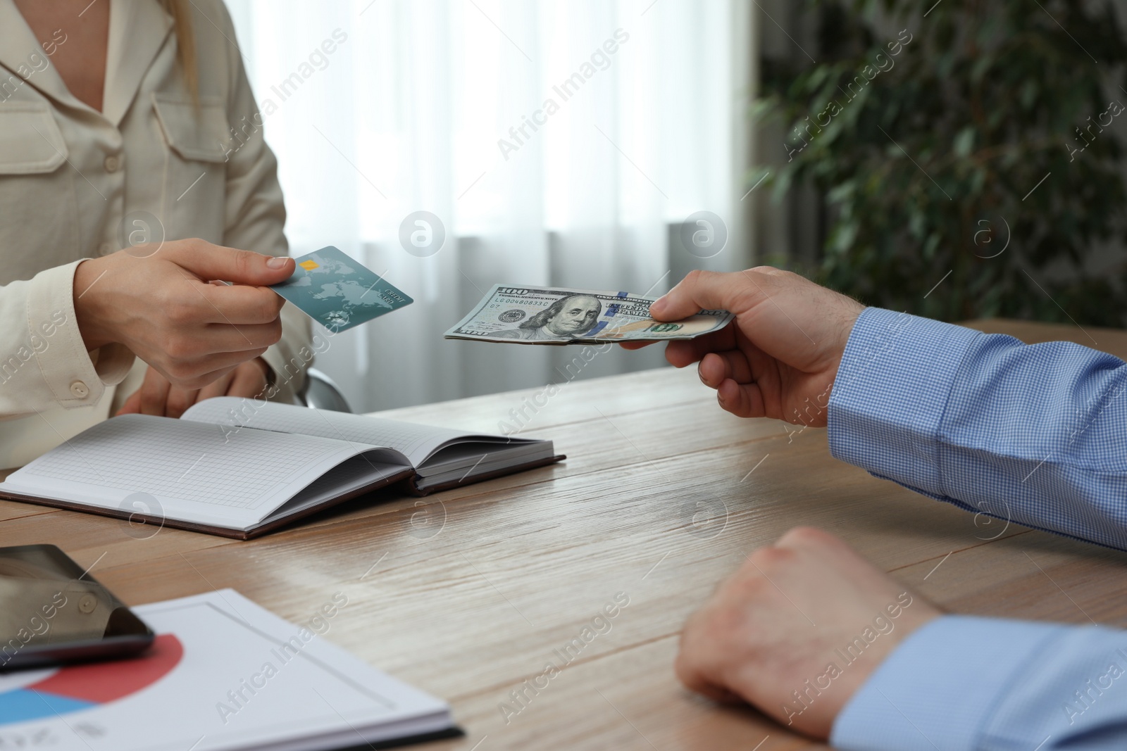 Photo of Businessman putting money on card at desk in bank, closeup