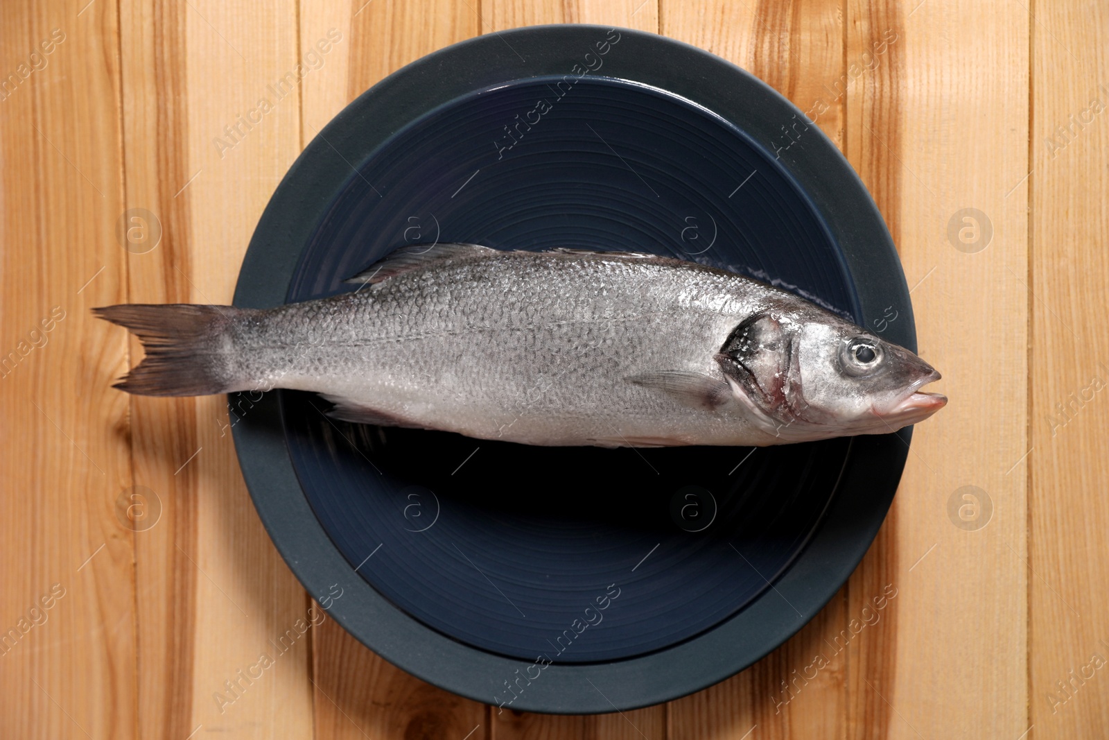 Photo of Fresh raw fish on wooden table, top view