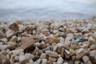 Photo of Coast with stones and pebbles on summer day, closeup