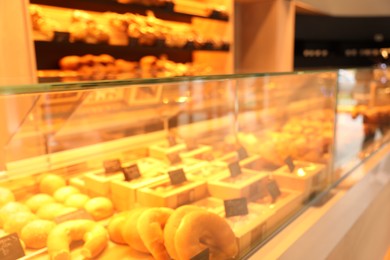 Blurred view of fresh pastries on counter in bakery store