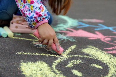 Child drawing family with chalk on asphalt, closeup