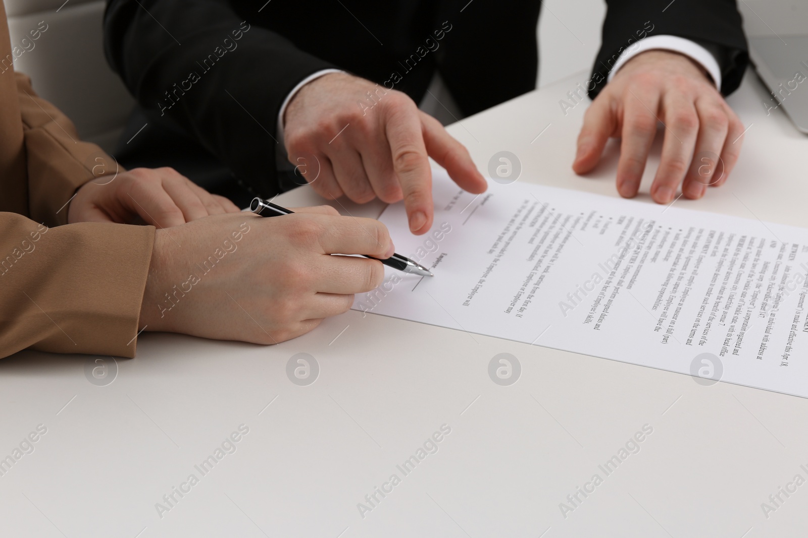 Photo of Businesspeople signing contract at white table, closeup of hands