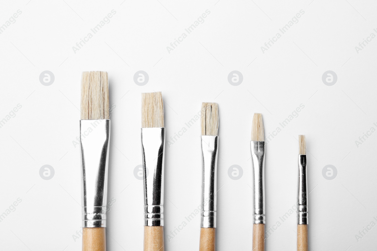 Photo of Different paint brushes on white background, top view