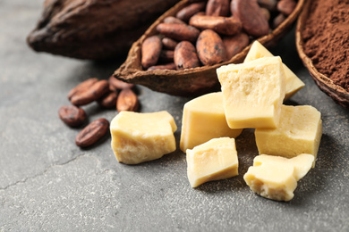 Photo of Organic cocoa butter on grey table, closeup view