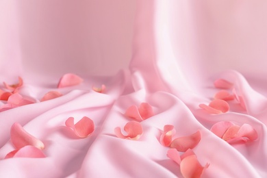 Photo of Beautiful rose petals on soft pink fabric