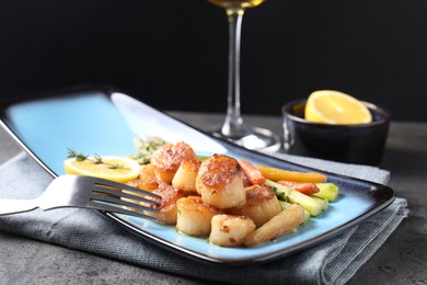 Photo of Delicious fried scallops with asparagus served on grey table