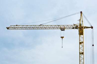 Photo of Modern tower crane against cloudless sky. Construction site