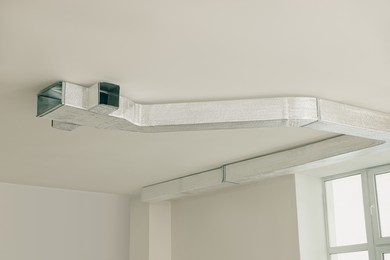 Modern pipe installed on ceiling indoors. Home renovation