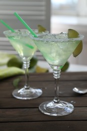 Photo of Delicious Margarita cocktail in glasses on wooden table