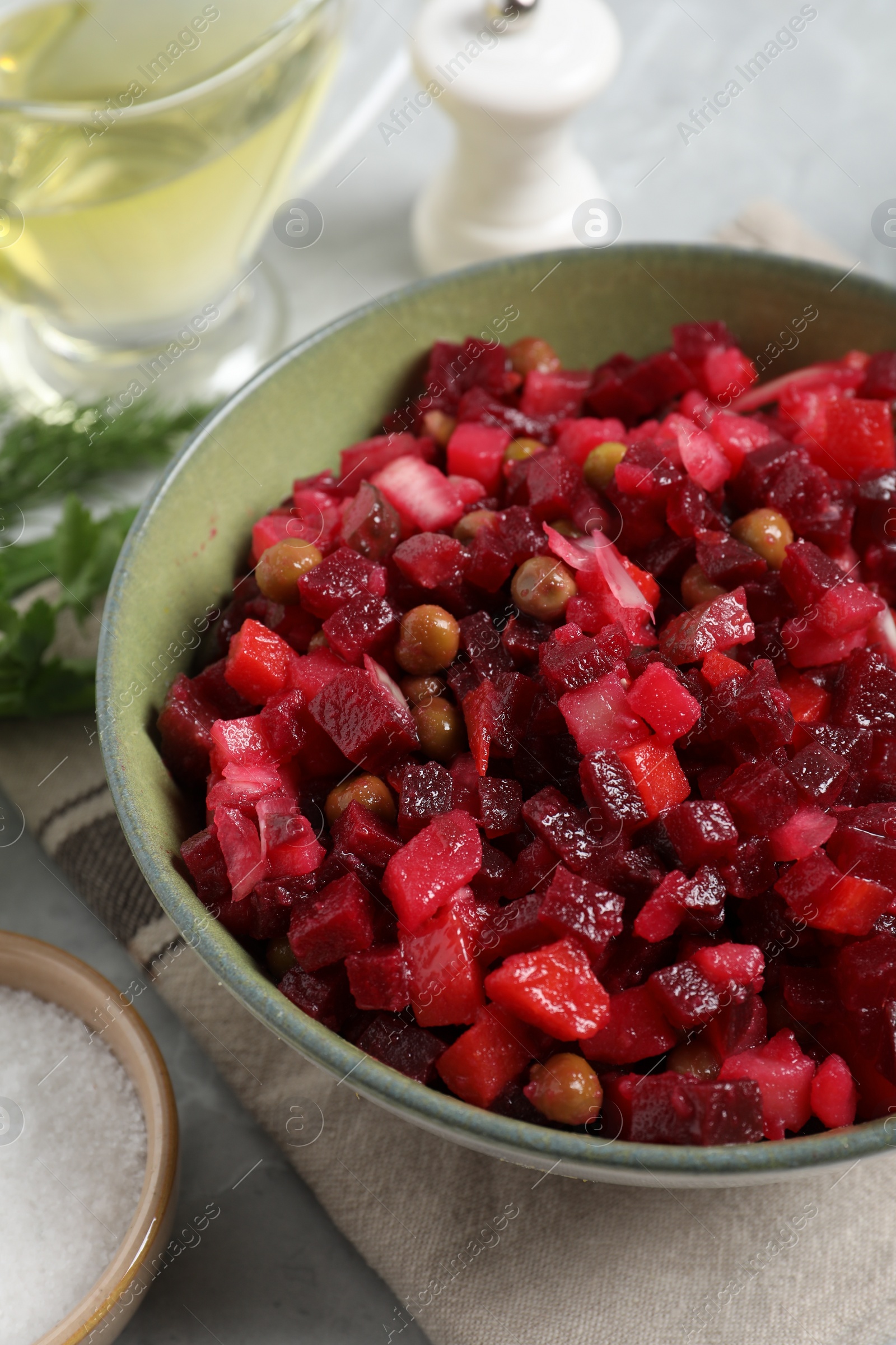 Photo of Bowl of delicious fresh vinaigrette salad on table, closeup