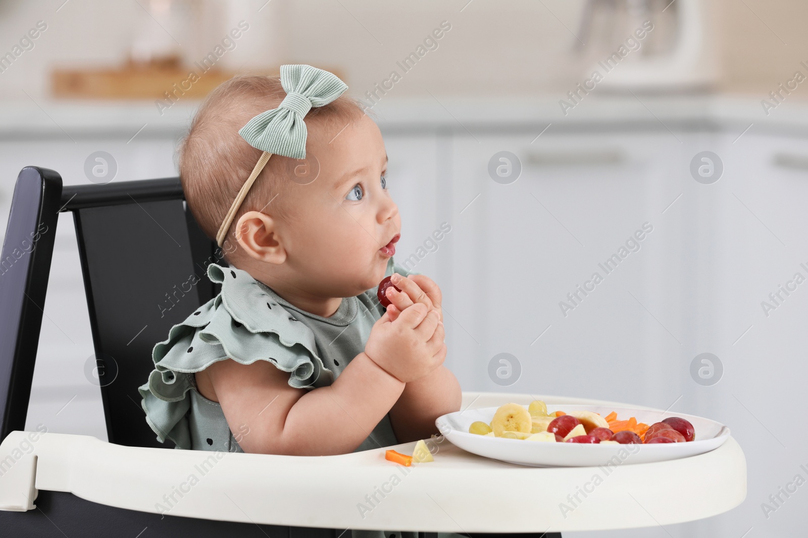 Photo of Cute little girl eating healthy food at home