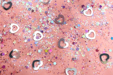 Photo of Shiny glitter on light pink background, flat lay