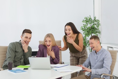 Photo of Group of colleagues laughing together in office