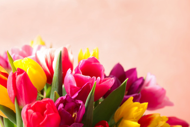 Photo of Beautiful spring tulips on light pink background, closeup