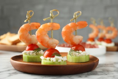 Photo of Tasty canapes with shrimps, vegetables and cream cheese on white marble table, closeup