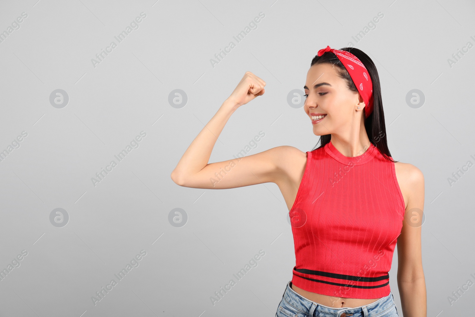 Photo of Strong woman as symbol of girl power on light grey background, space for text. 8 March concept