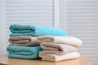 Stacks of clean towels on table indoors