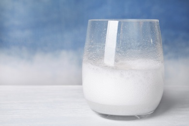 Chemical reaction of vinegar and baking soda in glass on table. Space for text