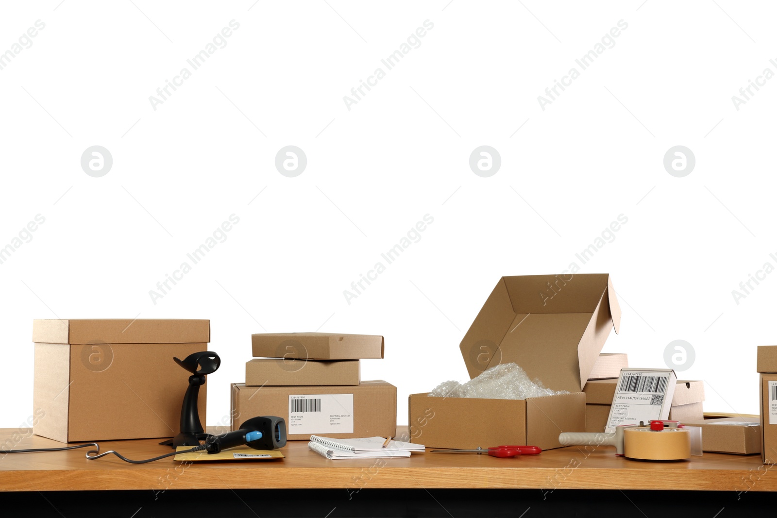 Photo of Parcels, barcode scanner and stationary on wooden table against white background. Online store