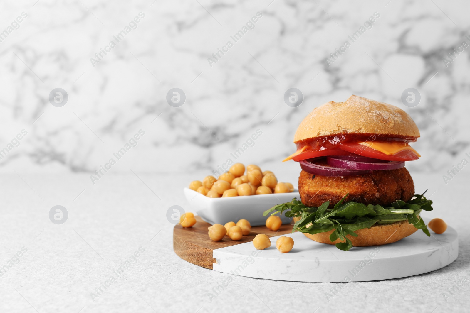 Photo of Tasty vegetarian burger with chickpea cutlet on white table, space for text