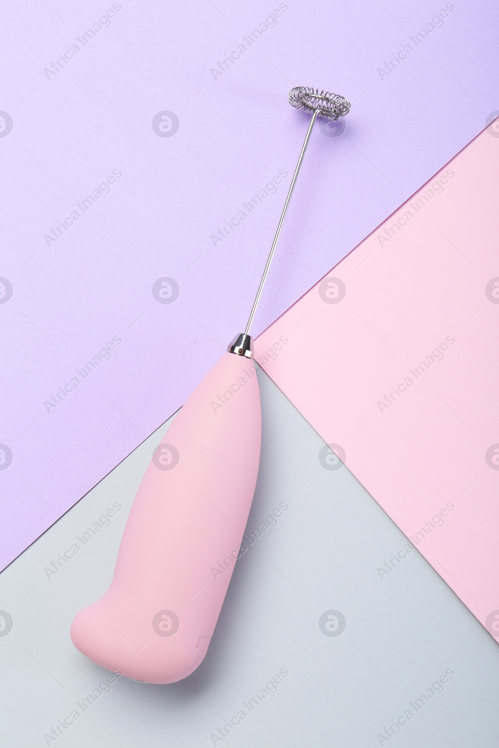 Photo of Pink milk frother wand on color background, top view