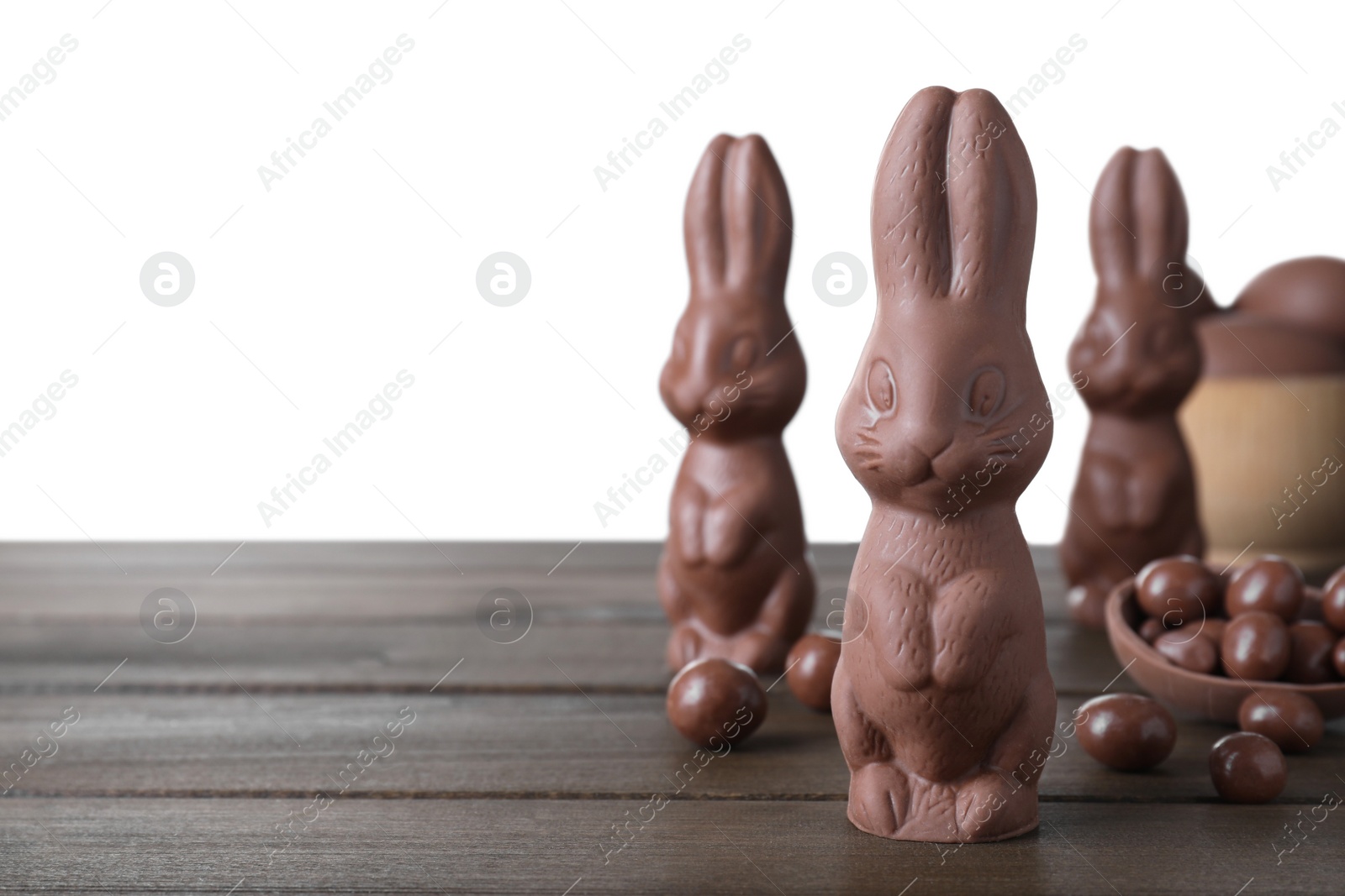 Photo of Chocolate Easter bunnies and candies on wooden table against white background. Space for text