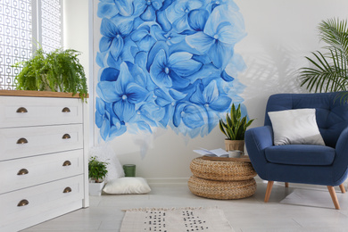 Stylish living room with blue flowers painted on wall. Floral pattern in interior design