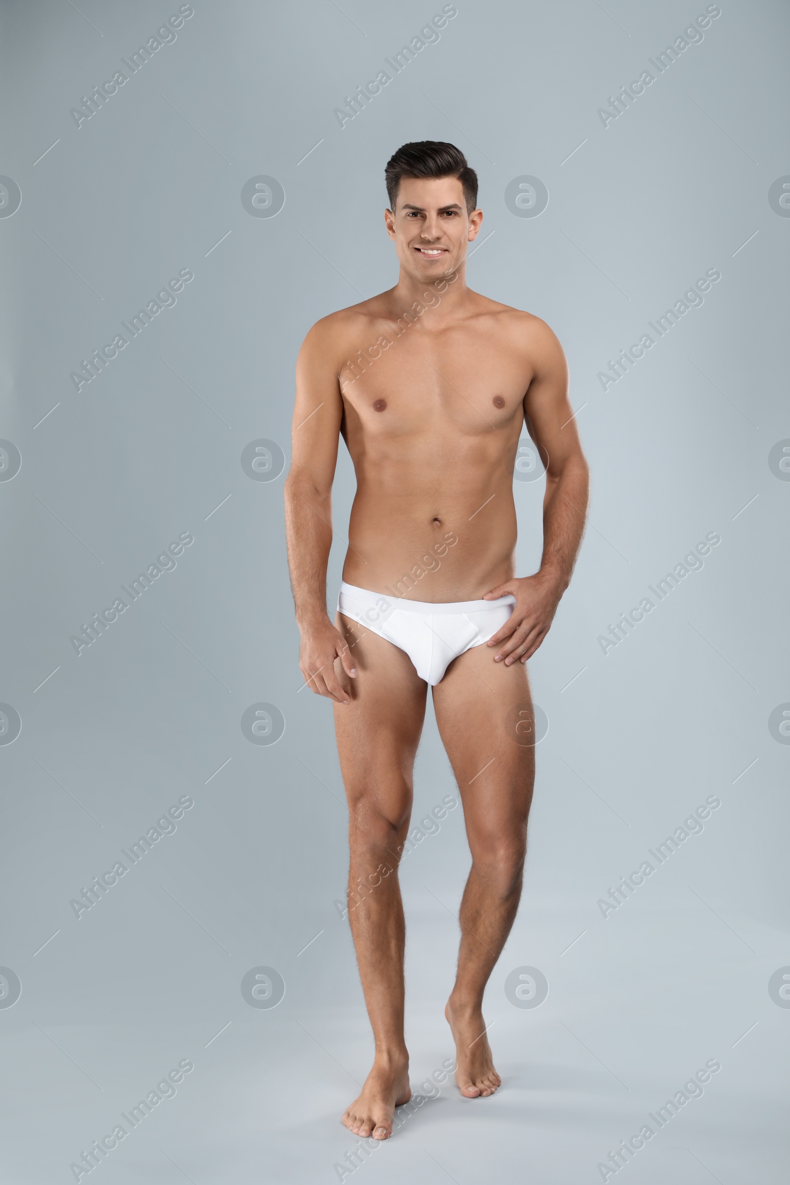 Photo of Handsome man in white underwear on light grey background