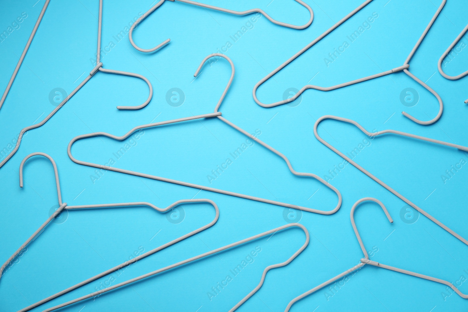 Photo of Hangers on light blue background, flat lay