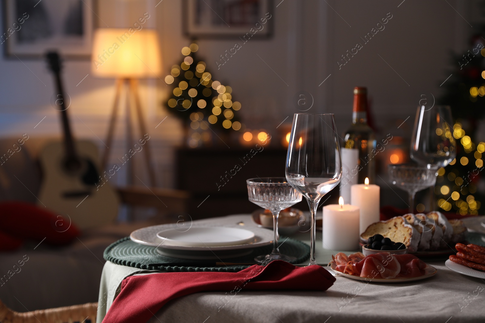 Photo of Christmas table setting with burning candles, appetizers and dishware. Space for text