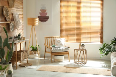 Stylish living room interior with comfortable wooden armchair and beautiful houseplants