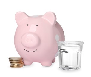 Photo of Water scarcity concept. Piggy bank, coins and glass of drink on white background