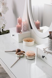 Photo of Wooden dressing table with decorative elements and makeup products in room